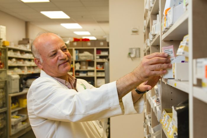 Pharmacist reaching for some medication